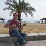 Danny Medved serenades passers-by on a beach on the Dead Sea.