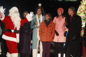 U.S. President Obama, first lady and their daughters sing alongside an actor dressed as Santa in Washington